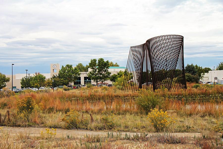 的 能源 sculpture is shown in the foreground with the clocktower building in the background.