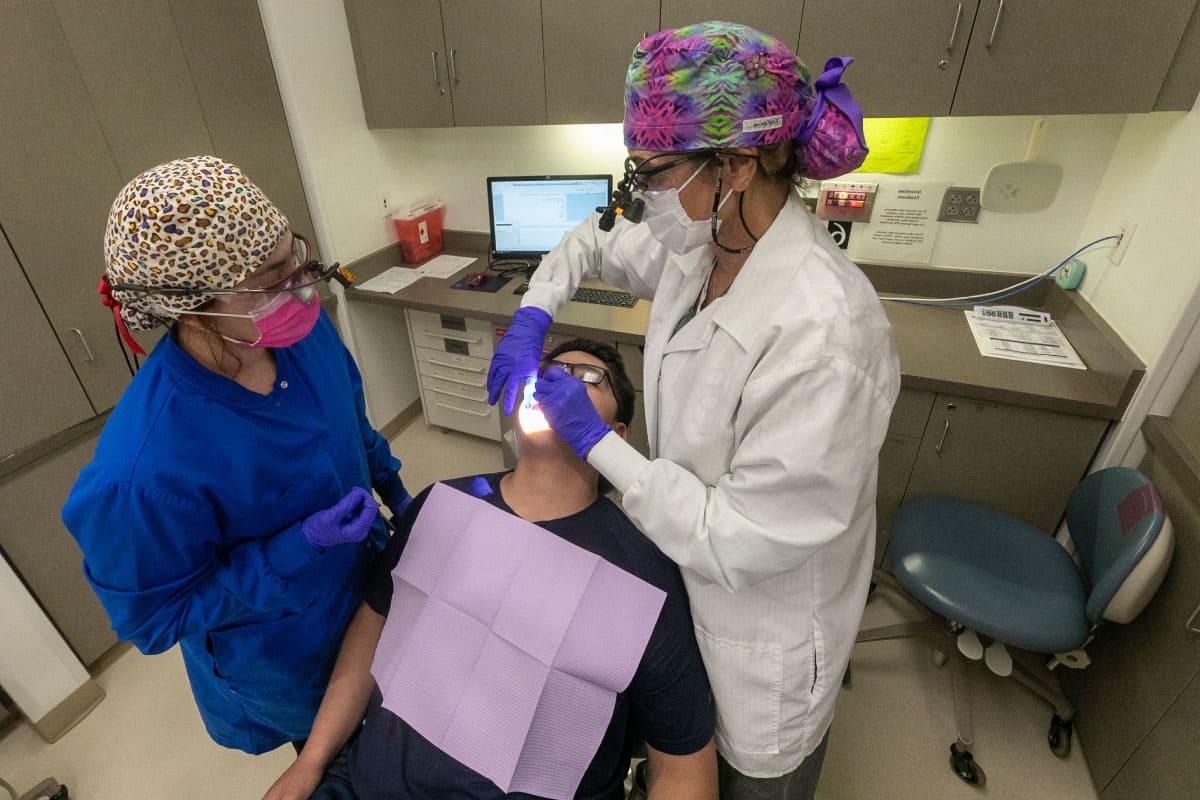 Two 太阳集团娱乐场登陆网站 dental students work on a patient